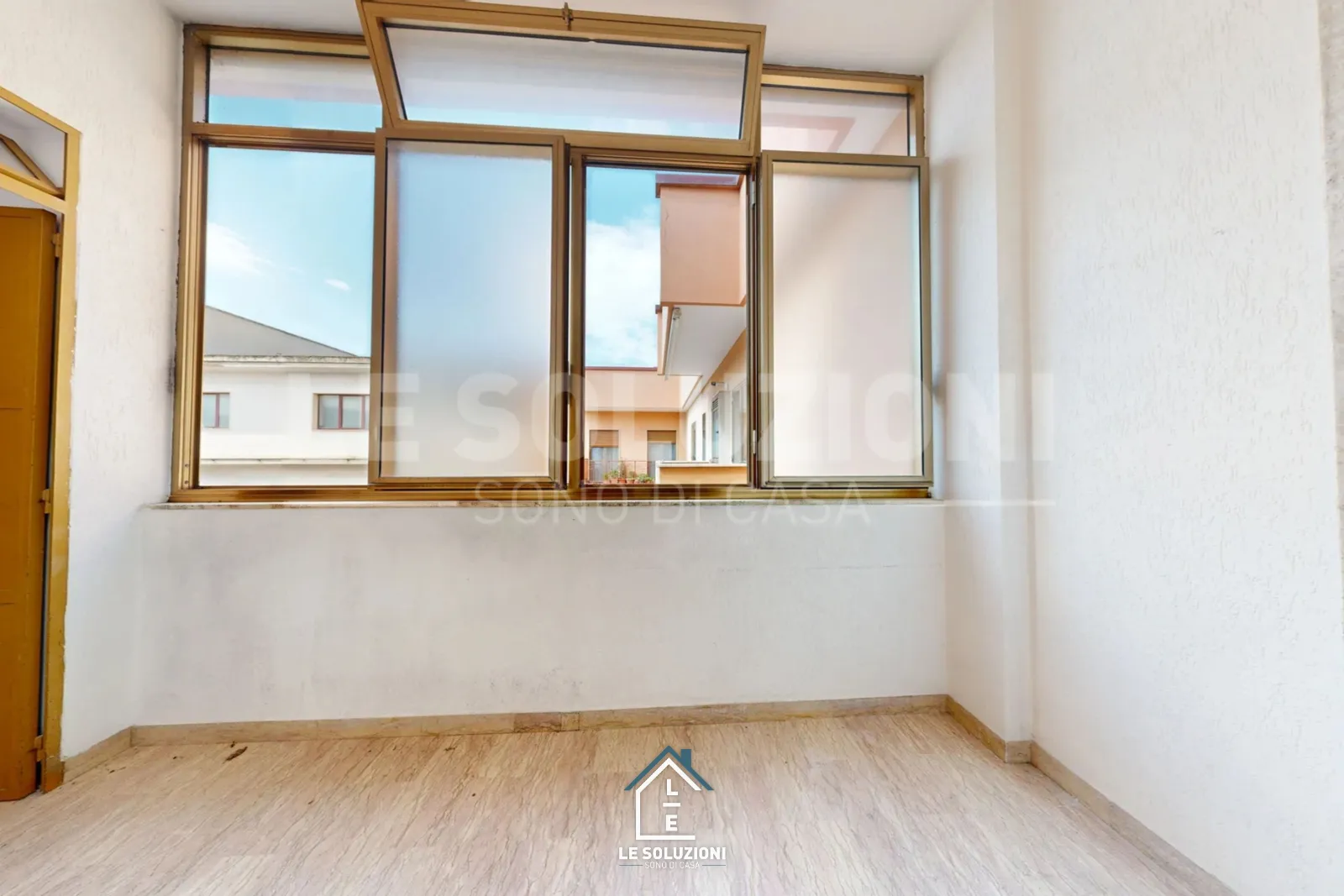 Camera vuota con finestra ad ante dorate su cortile – Appartamento a Putignano