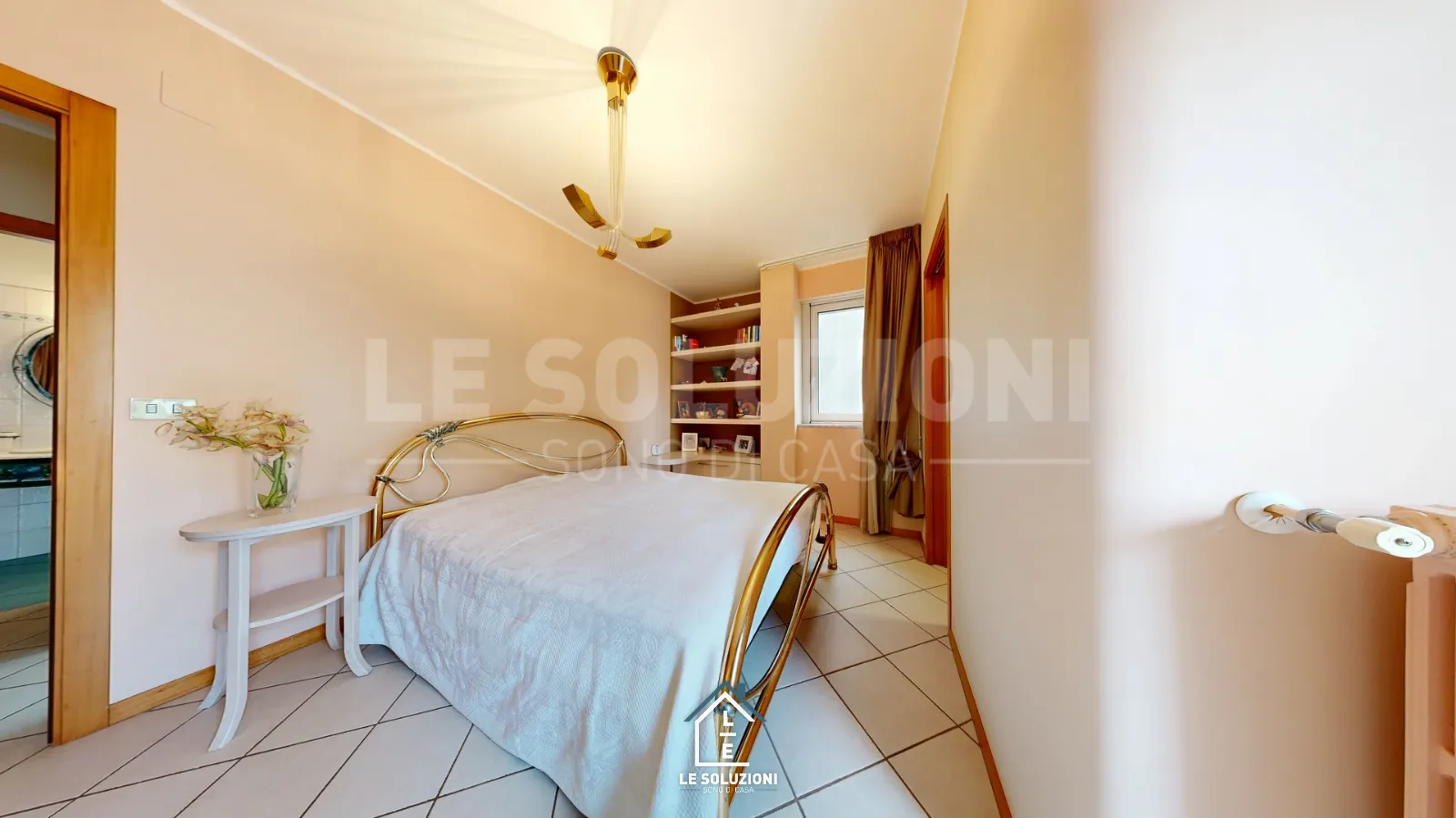 Camera da letto con letto in ferro dorato e libreria a muro – Appartamento a Putignano