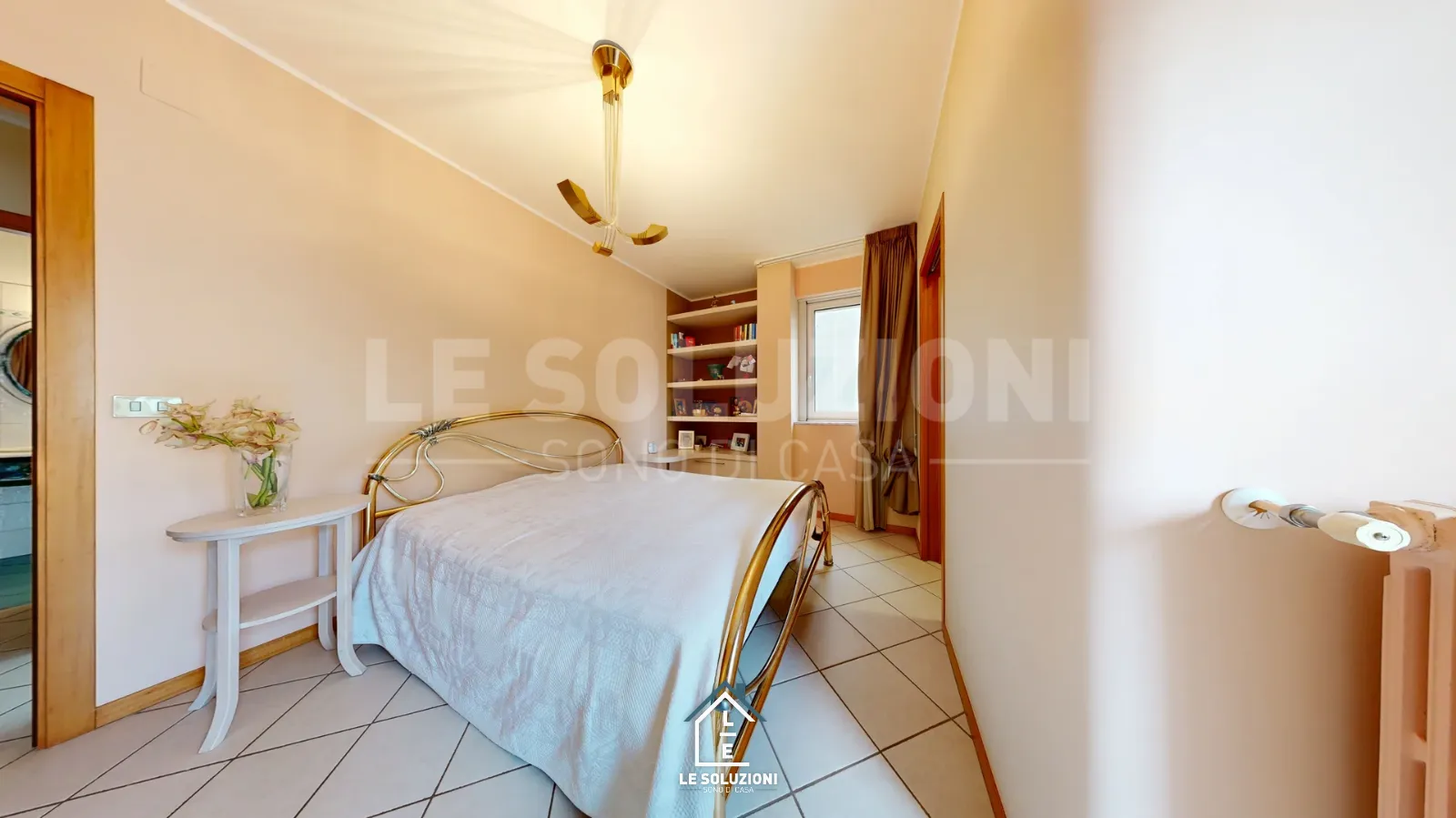 Camera da letto con letto in ferro dorato e finestra – Appartamento a Putignano