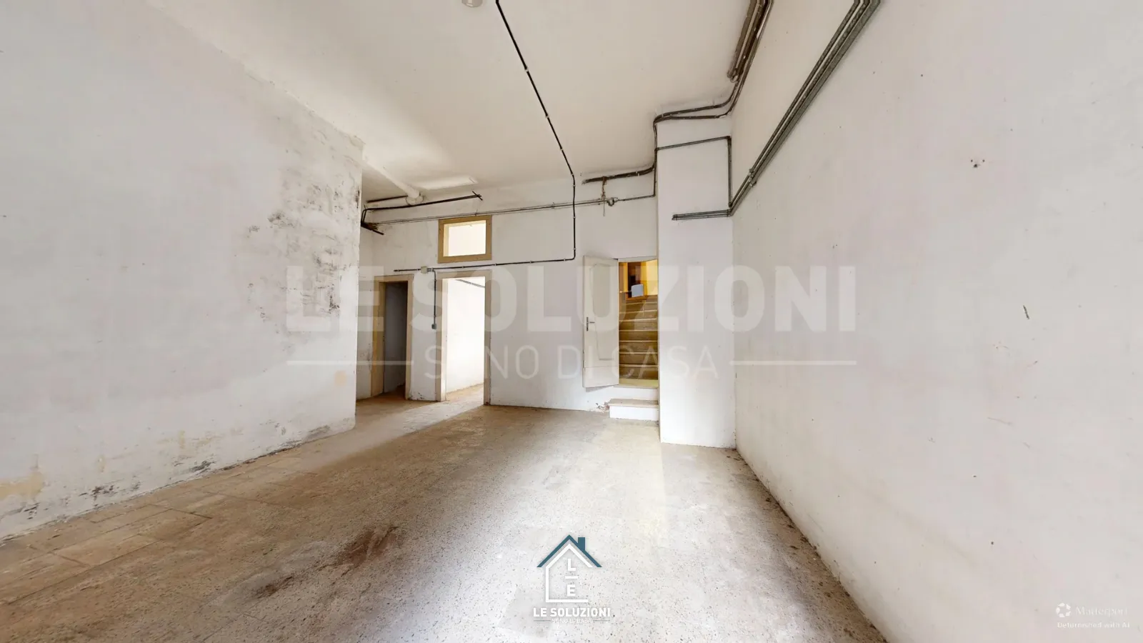 Locale grezzo con due porte e scala interna a vista – Appartamento a Putignano