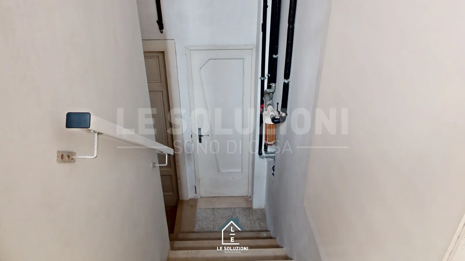Scala interna stretta con corrimano e tubazioni a vista – Appartamento a Putignano